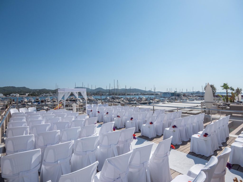 Ceremonia con sillas de boda y vistas al puerto