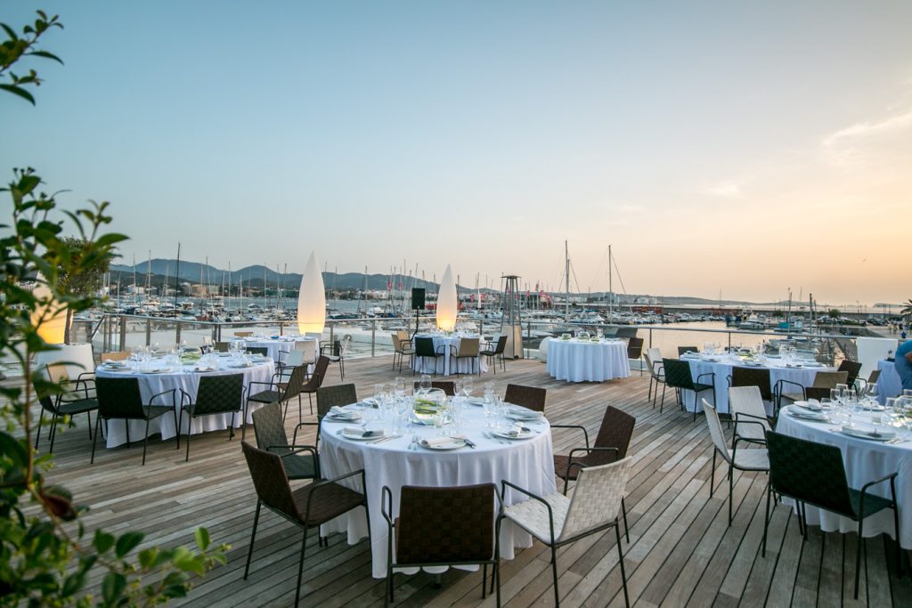 Terraza restaurante al atardecer con mesas decoradas para una boda