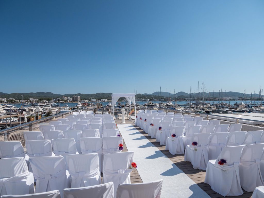 Ceremonia con sillas de boda y vistas al puerto