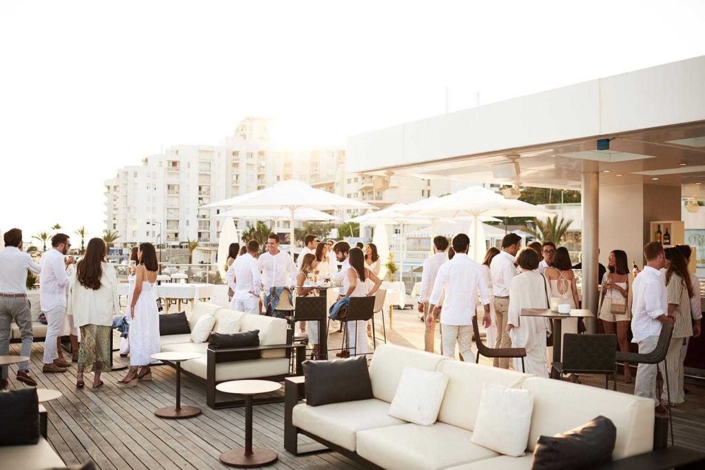 Gente al atardecer en la terraza con vistas al puerto