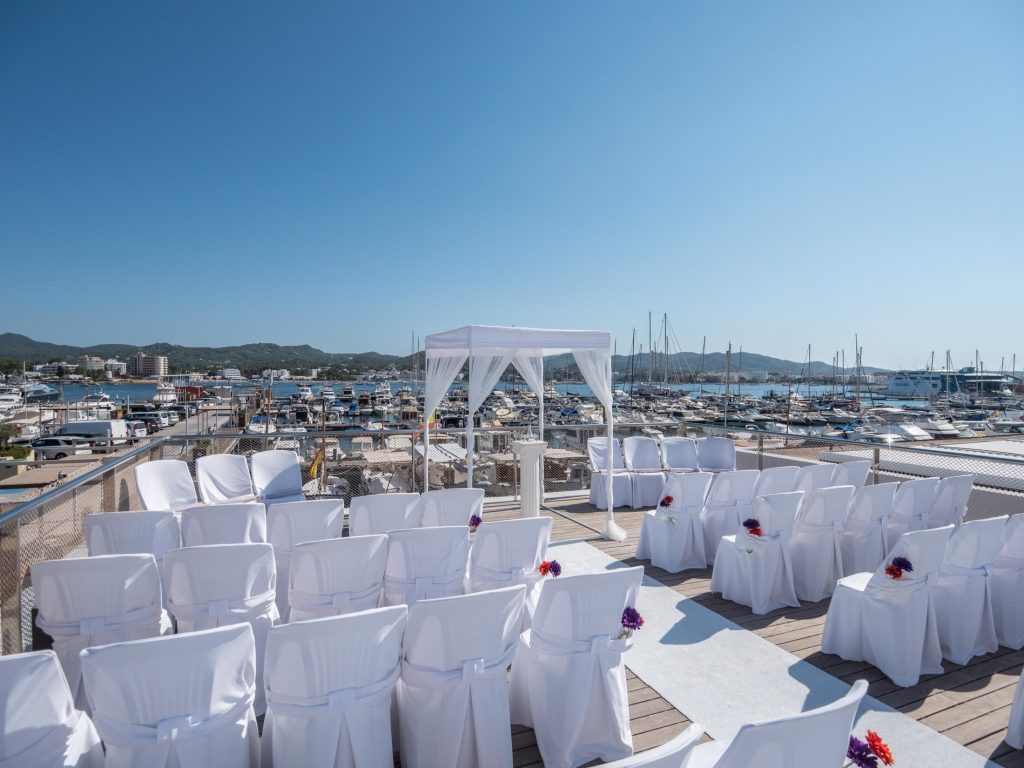 Ceremonia con sillas de boda y vistas al puerto